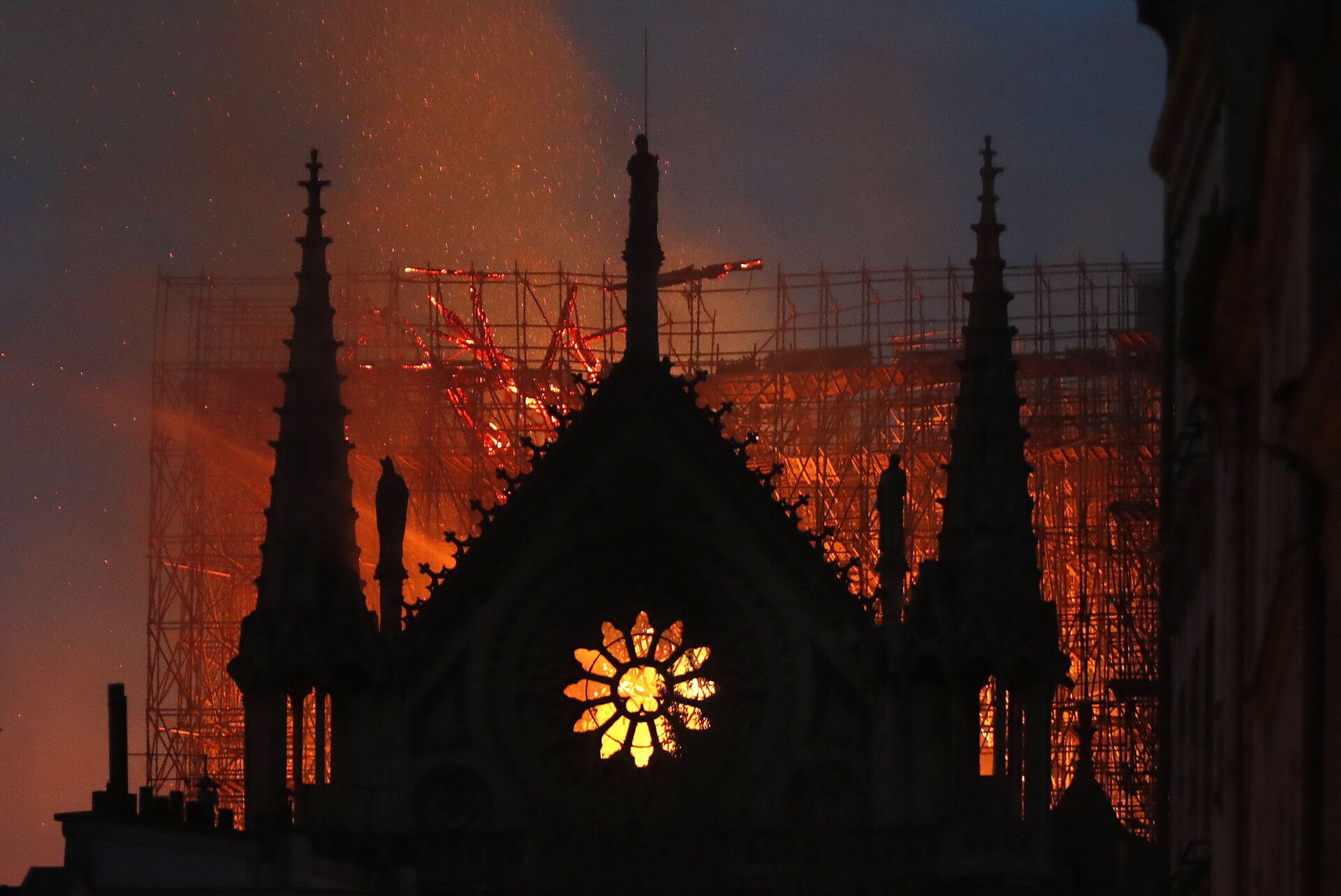 In this April 15, 2019, file photo, flames and smoke rise from Notre Dame Cathedral as it burns in Paris. The cathedral stands crippled, locked in a dangerous web of twisted metal scaffolding one year after a cataclysmic fire gutted its interior, toppled its famous spire and horrified the world. (AP Photo/Thibault Camus, File) - Sputnik International, 1920, 12.01.2025