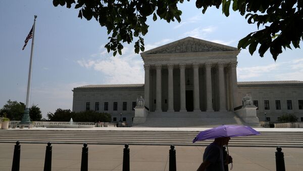 A pedestrian holding an umbrella walks along First Street, as a series of rulings are issued at the United States Supreme Court in Washington, U.S., July 6, 2020 - Sputnik International