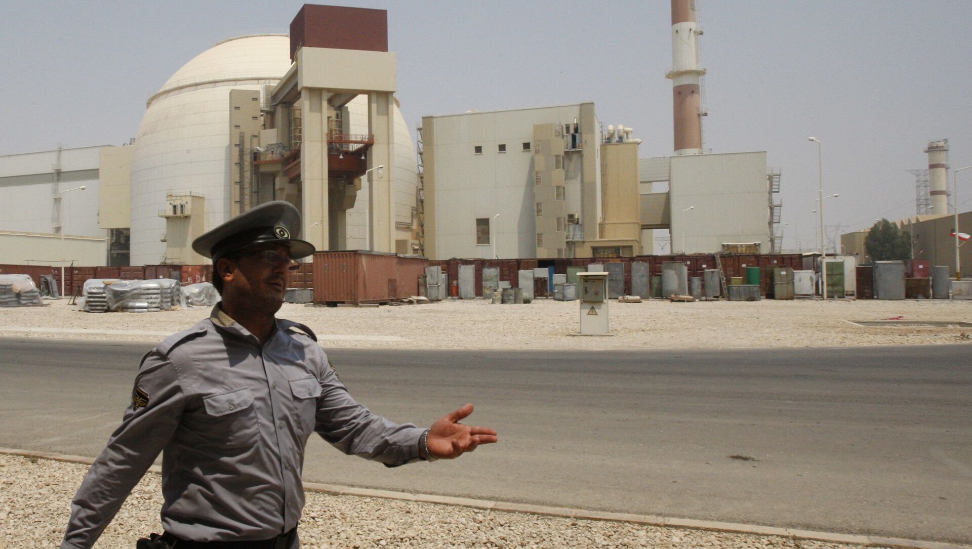 An Iranian security directs media at the Bushehr nuclear power plant, with the reactor building seen in the background, just outside the southern city of Bushehr, Iran, Saturday, Aug. 21, 2010 - Sputnik International, 1920, 22.02.2021