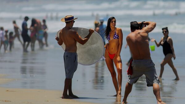 A woman poses for a photographer in the Pacific Beach area of San Diego, California on Saturday, 4 July 2020, amid the coronavirus pandemic. Many beaches have been shut down for the Fourth of July weekend across California due to a resurgence of COVID-19 cases. San Diego area beaches, however, have remained open.  - Sputnik International