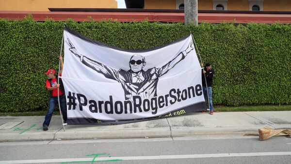 Demonstrators display a banner calling for the pardoning of former Trump presidential campaign advisor Roger Stone, as the presidential motorcade passes through West Palm Beach, Florida - Sputnik International
