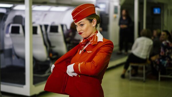 A stewardess puts on her jacket as flight staffers practise emergency landing techniques at the Russian Aeroflot company Training Complex of the Aviation Personnel Training Center for search-and-rescue training LAND-WATER at Sheremetevo airport outside Moscow on December 25, 2019 - Sputnik International