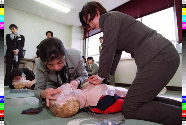 Flight attendant recruits for Japan Airlines practice artificial respiration on dolls during an induction course at the firm's training centre in Tokyo 14 April - Sputnik International
