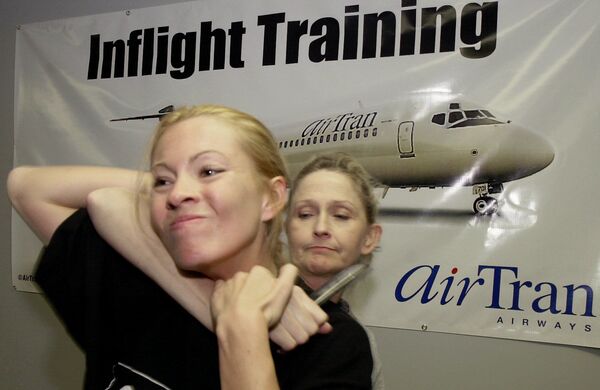 AirTran Airways flight attendant Clarissa Zimmermann, left, fends off an attacker played by fellow flight attendant Helen Ward, during a personal defence course given to AirTran flight attendants by instructors from Intelligence Strategies, Wednesday, Feb. 13, 2002, at the airline's training facility in College Park, Ga - Sputnik International