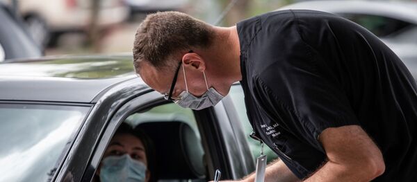 Ella Speer speaks with a doctor before getting tested in for the coronavirus disease (COVID-19) during an outbreak in Austin, Texas, U.S., June 28, 2020. - Sputnik International