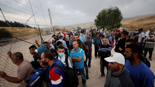 Palestinian labourers, who were not able to cross into Israel for work, gather near an Israeli checkpoint that was closed amid fears of a second wave of coronavirus disease (COVID-19) infections, near Hebron in the Israeli-occupied West Bank 29 June 2020.  - Sputnik International