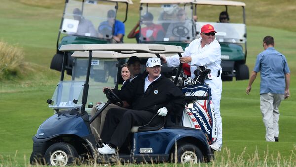 US President Donald Trump (C) sits in a golf cart as he plays a round of golf on the Ailsa course at Trump Turnberry, the luxury golf resort of US President Donald Trump, in Turnberry, southwest of Glasgow, Scotland on July 14, 2018 - Sputnik International