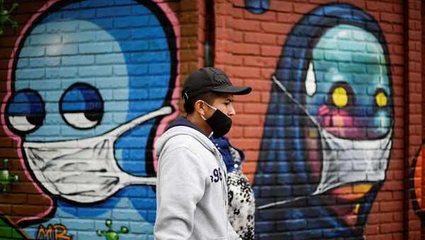 A couple wearing face masks walk by a wall with graffitis after health authorities reverse the measures of reopening following the increase in cases of the coronavirus disease (COVID-19) in San Jose, Costa Rica July 13, 2020. - Sputnik International