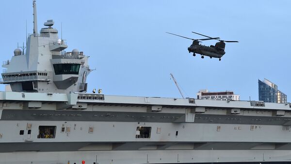A Chinook helicopter flies over the HMS Queen Elizabeth aircraft carrier, following an event to commemorate the 75th anniversary of the D-Day landings, in Portsmouth, southern England, on June 5, 2019. - Sputnik International