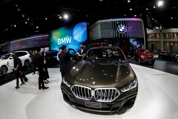 People wearing face masks are seen near the BMW X6 xDrive30d M Sport during the media day of the 41st Bangkok International Motor Show after the Thai government eased measures to prevent the spread of the coronavirus disease (COVID-19) in Bangkok, Thailand July 14, 2020.  - Sputnik International