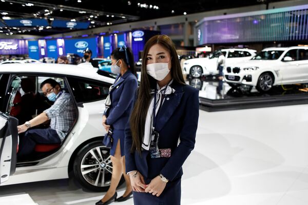 A representative of a BMW dealership wears a face mask during the media day of the 41st Bangkok International Motor Show after the Thai government eased measures to prevent the spread of the coronavirus disease (COVID-19) in Bangkok, Thailand July 14, 2020. - Sputnik International