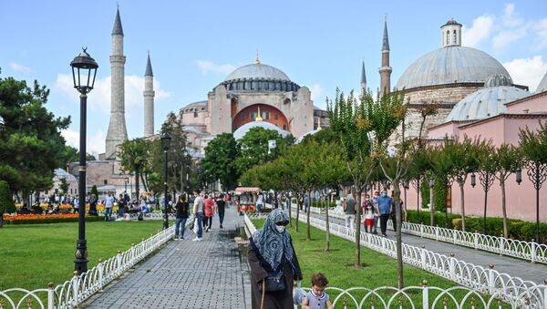 People walk in front of Hagia Sophia on July 11, 2020 in Istanbul, a day after a top Turkish court revoked the sixth-century Hagia Sophia's status as a museum, clearing the way for it to be turned back into a mosque. - Sputnik International