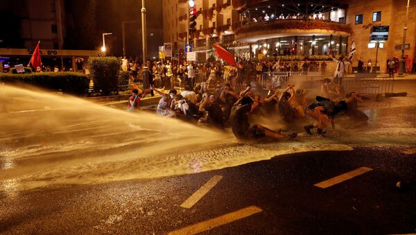 Police use water cannons as they clash with people during a protest against Israeli Prime Minister Benjamin Netanyahu and his government's response to the financial fallout of the coronavirus disease (COVID-19) crisis outside Prime Minister Benjamin Netanyahu's residence in Jerusalem July 15, 2020 - Sputnik International