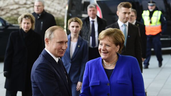 German Chancellor Angela Merkel, right, shakes hands with Russian President Vladimir Putin during arrivals for a conference on Libya at the chancellery in Berlin, Germany, Sunday, Jan. 19, 2020 - Sputnik International