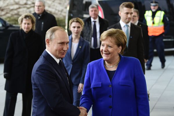 German Chancellor Angela Merkel, right, shakes hands with Russian President Vladimir Putin during arrivals for a conference on Libya at the chancellery in Berlin, Germany, Sunday, Jan. 19, 2020 - Sputnik International