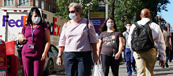 People walk while wearing protective masks as New York City moves into Phase 3 of re-opening following restrictions imposed to curb the coronavirus pandemic on July 14, 2020.  - Sputnik International