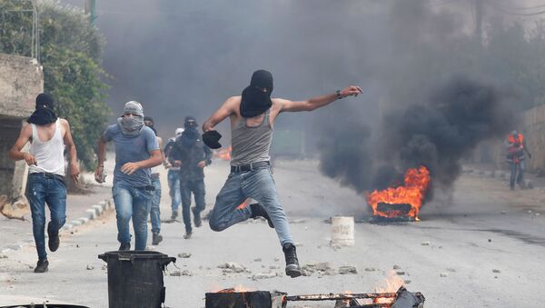 A demonstrator jumps during an anti-Israel protest following the funeral of Palestinian man Ibraheem Yakoub, in Kifl Haris in the Israeli-occupied West Bank, 10 July 2020 - Sputnik International