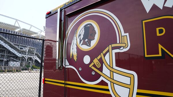 The Washington Redskins team logo is seen on a vehicle parked outside the NFL team's stadium FedEx Field after the team announced it will be abandoning its controversial Redskins team name and logo under pressure from sponsors to scrap the name criticized as racist by Native American rights groups, in Landover, Maryland U.S., July 13, 2020 - Sputnik International
