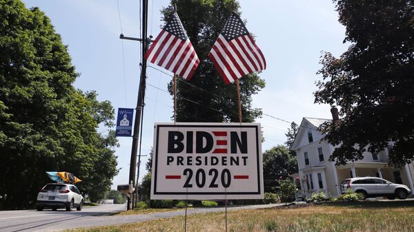 In this 23 June 2020, file photo, a car passes a yard displaying a campaign sign for Democrat presidential candidate, former vice-president Joe Biden in North Hampton, New Hampshire. The coronavirus pandemic isn't going away anytime soon, but campaigns are still forging ahead with in-person organising. The pandemic upended elections this year, forcing campaigns to shift their organising activities almost entirely online and compelling both parties to reconfigure their conventions.  - Sputnik International