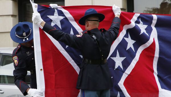 A Mississippi Highway Safety Patrol honor guard folds the retired Mississippi state flag after it was raised over the Capitol grounds one final time in Jackson, Miss., in a July 1, 2020 file photo. - Sputnik International