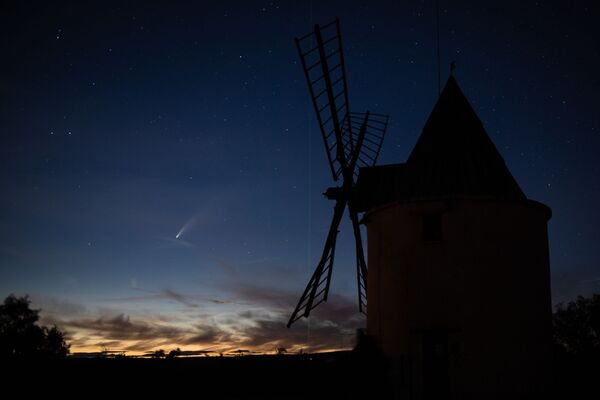 A picture taken on July 15, 2020 shows the C/2020 F3 comet (L), also known as NEOWISE, and the green laser beam used by the Haute-Provence Observatory to point to celestial objects for studies and research (C), with an old windmill in the foreground at Saint-Michel-L'Observatoire, southern France - Sputnik International