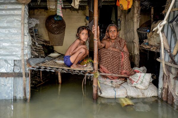 A woman and a young girl sitting in their flooded house in Sunamganj on July 16, 2020 - Sputnik International