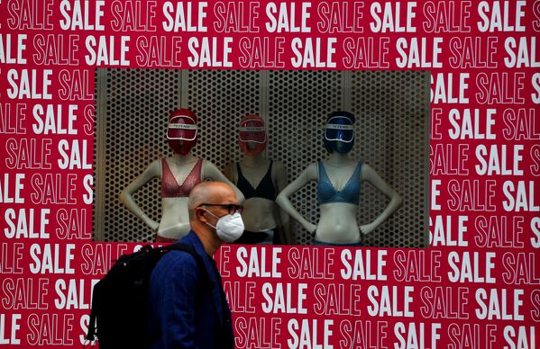 A man wearing a protective face mask walks past a shop window in London, Tuesday, July 14, 2020 - Sputnik International