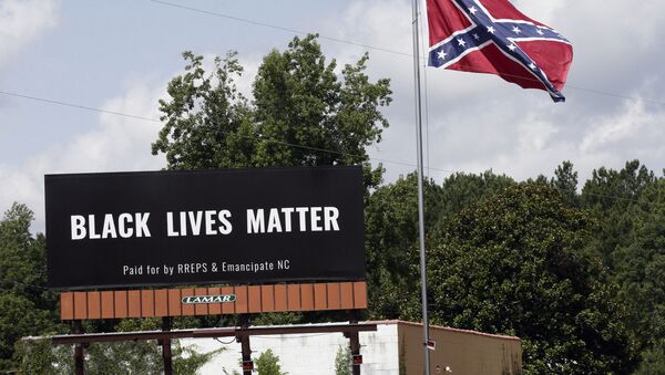 A Black Lives Matter billboard is seen next to a Confederate flag in Pittsboro, N.C., Thursday, July 16, 2020. A group in North Carolina erected the billboard to counter the flag that stands along the road. - Sputnik International