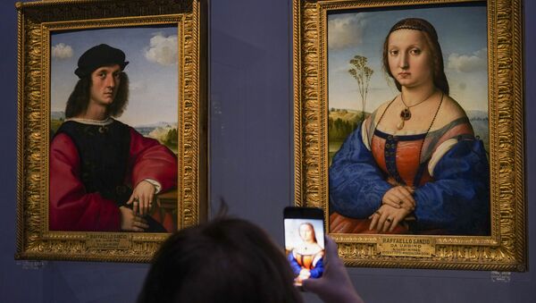 A member of the media takes pictures of 15th century paintings Portraits of Angelo, left, and Maddalena Doni by Raffaello Sanzio da Urbino, during a press tour of the Uffizi museum on the day off its reopening, in Florence, Wednesday, June 3, 2020. The Uffizi museum reopened to the public after over two months of closure due to coronavirus restrictions. - Sputnik International