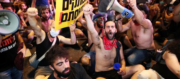 Israelis block a main junction in the city as they protest against the government's response to the financial fallout of the coronavirus disease (COVID- 19) crisis in Tel Aviv, Israel July 11, 2020 - Sputnik International