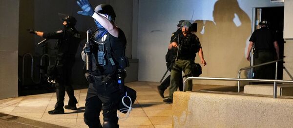 A Portland Police Bureau officer shields his eyes from a flashlight after confronting a crowd during a protest against racial inequality in Portland, Oregon, US July 17, 2020 A Portland Police Bureau officer shields his eyes from a flashlight after confronting a crowd during a protest against racial inequality in Portland, Oregon, US July 17, 2020 - Sputnik International