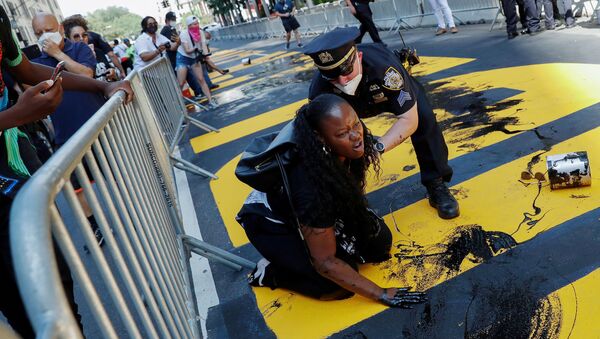 An officer from the New York Police Department (NYPD) attempts to detain a protester smearing paint on the Black Lives Matter mural outside of Trump Tower on Fifth Avenue in Manhattan, New York City, U.S.,18  July 2020. - Sputnik International
