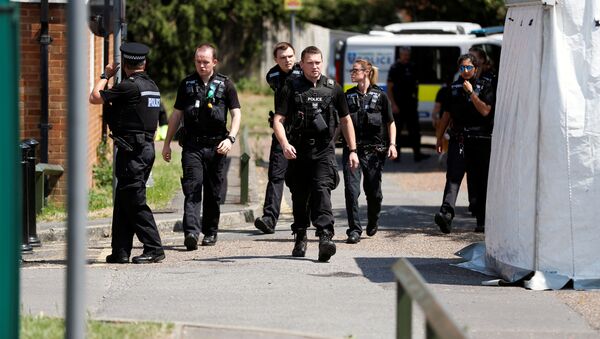 Police officers walk near the block where the suspect of multiple stabbings allegedly lived, in Reading, Britain, 23 June 2020. - Sputnik International