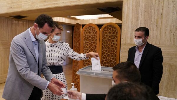 Syria's President Bashar al-Assad and his wife Asma cast their vote inside a polling station during the parliamentary elections in Damascus, Syria in this handout released by SANA on July 19, 2020 - Sputnik International
