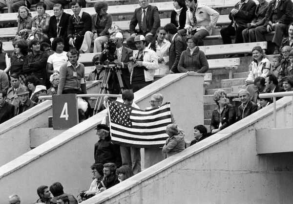 Three visitors display an American flag in the stands at Moscow's Lenin Stadium before the start of opening ceremonies of the XXII Summer Olympics, July 19, 1980 - Sputnik International