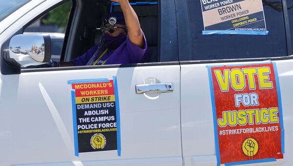 A man gestures as local fast food workers, ride-share drivers, and long-term care workers participate in a caravan protest as part of a nationwide strike for Black lives in Los Angeles, California, U.S., July 20, 2020. - Sputnik International