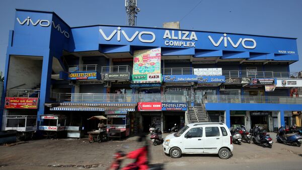 A scooterist rides past a shopping complex with the billboard of Chinese smartphone maker Vivo in Ahmedabad, India, December 14, 2018 - Sputnik International