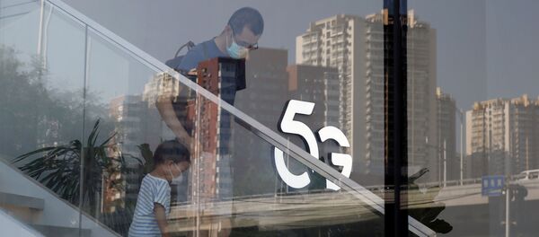 A man and a child wearing face masks following the coronavirus disease (COVID-19) outbreak walk past a 5G sign inside a Huawei store at a shopping mall in Beijing, China July 14, 2020 A man and a child wearing face masks following the coronavirus disease (COVID-19) outbreak walk past a 5G sign inside a Huawei store at a shopping mall in Beijing, China July 14, 2020 - Sputnik International