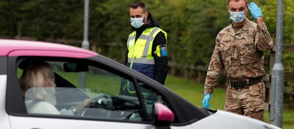 A soldier wearing a protective mask gestures as he directs cars into a coronavirus disease (COVID-19) testing center, as Blackburn with Darwen Council imposes local restrictions in an effort to avoid a local lockdown being forced upon the area, amid the coronavirus disease (COVID-19) outbreak, in Blackburn, Britain July 16, 2020 A soldier wearing a protective mask gestures as he directs cars into a coronavirus disease (COVID-19) testing center, as Blackburn with Darwen Council imposes local restrictions in an effort to avoid a local lockdown being forced upon the area, amid the coronavirus disease (COVID-19) outbreak, in Blackburn, Britain July 16, 2020 - Sputnik International