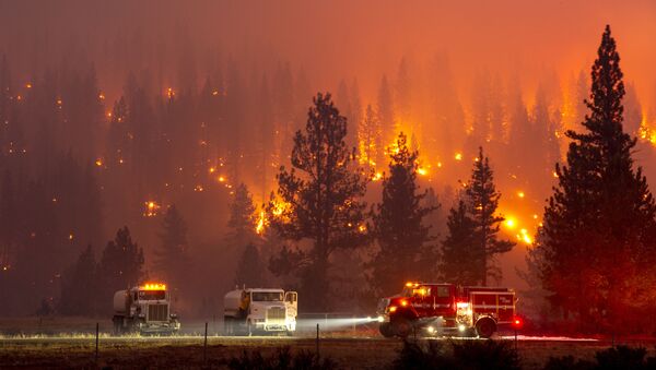 In this long exposure photograph, firefighters mop up hot spots from the Hog fire along Highway 36 about 5 miles from Susanville, California on July 20, 2020 - Sputnik International
