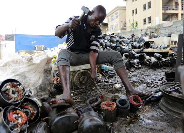 A man works on discarded compressors at a recycling centre in Abuja, Nigeria June 18, 2020 - Sputnik International