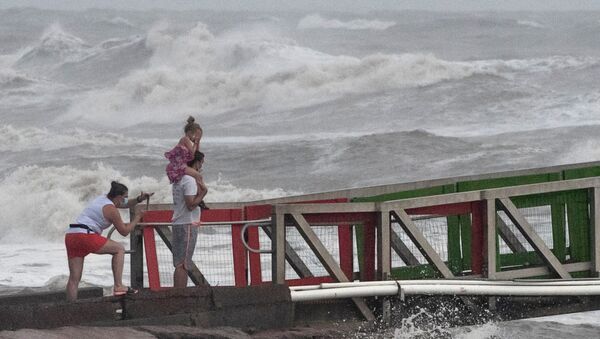 A girl covers her face from strong winds as her family members watch high swells from Hurricane Hanna from a jetty in Galveston, Texas, U.S., July 25, 2020. - Sputnik International