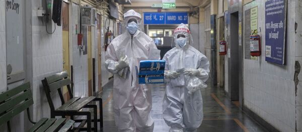 Medical workers wearing personal protective equipment (PPE) walk through a ward for patients suffering from the coronavirus disease  - Sputnik International