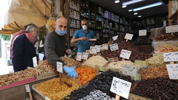 Vendors wearing protective face masks serve customers at a shop, ahead of the Muslim holy month of Ramadan, amid concerns over the coronavirus disease (COVID-19), in Amman, Jordan April 21, 2020. - Sputnik International