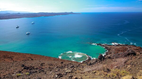 Final land excursion to Isla Bartomome and the lava beds on the E coast of Isla San Salvadore - last big climb up to the iconic Pinnacle Rock viewpoint - notice the outline of a crater in the ocean  - Sputnik International