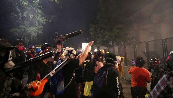 Demonstrators use leaf blowers to clear the tear gas during a protest against racial inequality and police violence in Portland, Oregon, U.S., July 27, 2020 - Sputnik International