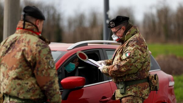 Members of the Italian army wearing protective face masks check the permission of a driver to enter the red zone of Turano Lodigiano, closed off due to a coronavirus outbreak in northern Italy, in Turano Lodigiano, Italy, February 26, 2020. - Sputnik International