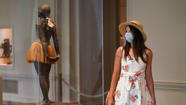A visitor wearing her face mask looks at the Degas sculpture Little Dancer Aged Fourteen at the National Gallery of Art's West Building, which reopened today after months of  closure due to the coronavirus disease (COVID-19) outbreak, in Washington, U.S., July 20, 2020 - Sputnik International