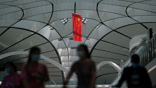 People wearing face masks following the coronavirus disease (COVID-19) outbreak walk under a Chinese flag at Beijing Daxing International Airport in Beijing, China July 24, 2020 - Sputnik International