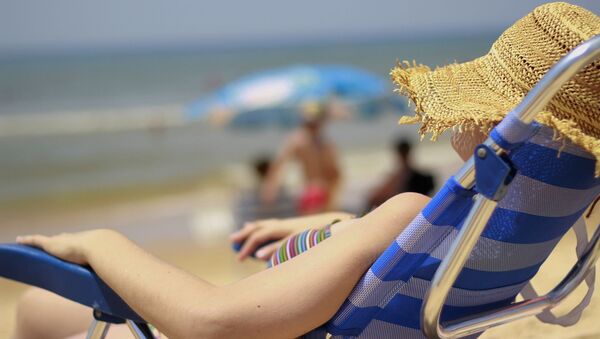 Woman relaxes on the beach in Matalascañas, Spain - Sputnik International